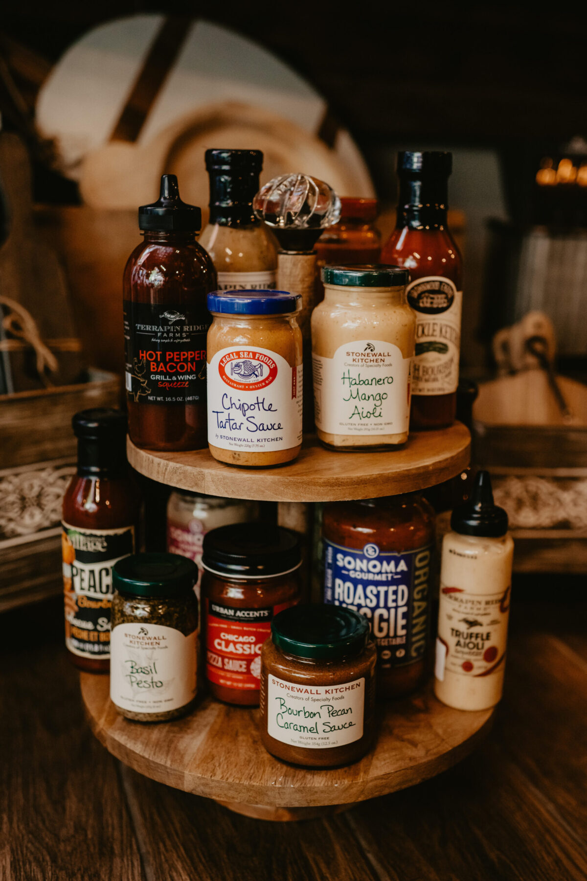 Assorted gourmet canned and bottled sauces arranged on a tiered wooden display